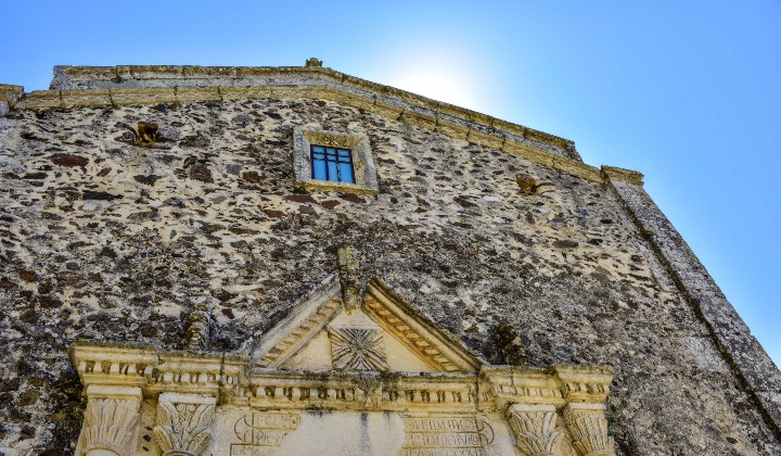 Prospetto frontale con portale decorato e monofora rettangolare