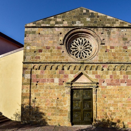 Facade in pink trachyte, with rose window, portal and a row of hanging arches. (photoIvo Piras)
