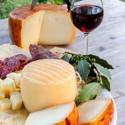 Cheeses, cured meats, and a wine. (photoAlessio Orrù - stock.adobe.com)