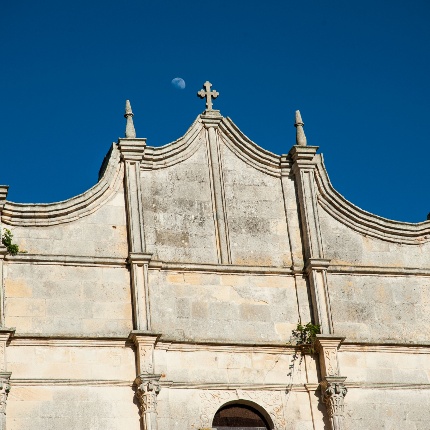 La parte terminale del prospetto adotta un timpano mistilineo sormontato da piccole guglie poste in corrispondenza delle scansioni verticali (foto Ivo Piras)