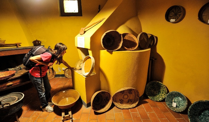 Wood-fired oven and display of baskets and containers used in the kitchen.
