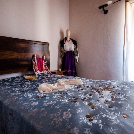 Stanza da letto con abiti della tradizione sarda (foto Angelo Marras)