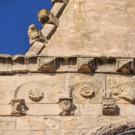 Detail of the horizontal frame on the facade, with rosettes, spheres, diamond points and human faces (photoIvo Piras)