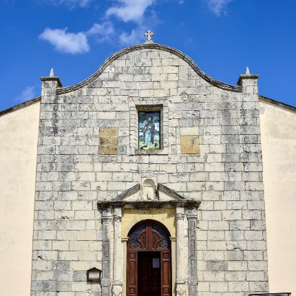 La facciata presenta il portale incorniciato da pilastrini e colonne a sostegno del timpano. Sopra finestrone rettangolare (foto Ivo Piras)