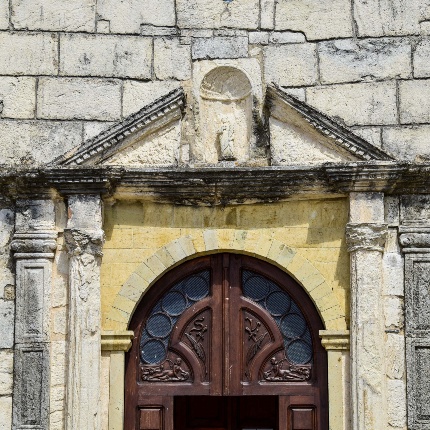 Particolare del portale con pilastrini, colonne e timpano superiore spezzato al centro da una nicchia (foto Ivo Piras)