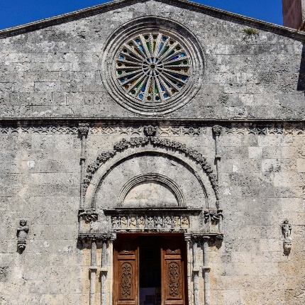 Il bel portale, con arco a tutto sesto e ghiera ornata da fogliami con fiorone, è affiancato da colonnine con capitello anch'esso a fiorone (foto Ivo Piras)