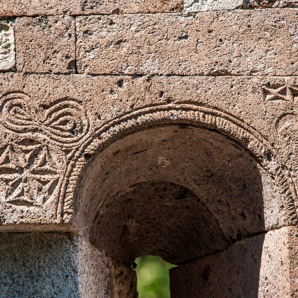 Parte alta di una monofora centinata con incisioni geometriche (foto Ivo Piras)